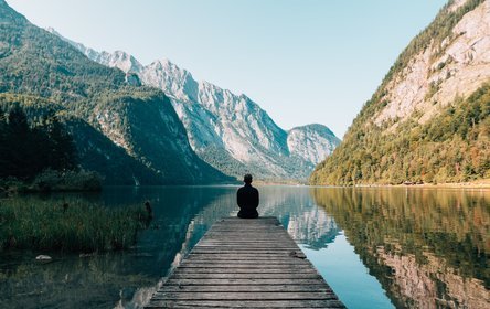 man meditating at the end of a jetty