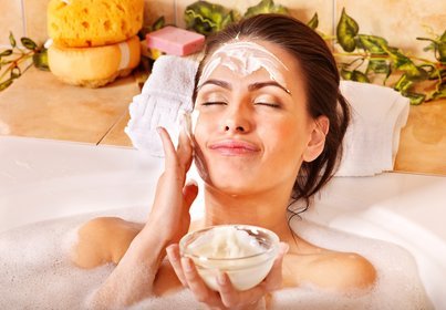 woman applying face mask in the bath