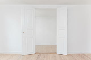 A bare space in a home with double white doors