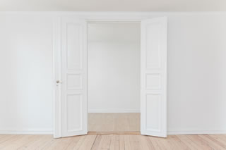 A bare space in a home with double white doors A bare space in a home with double white doors