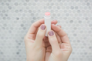 Two hands holding a moisturising lip balm