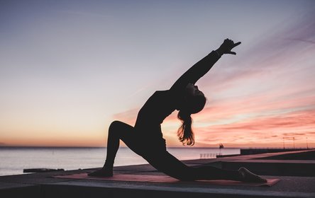 Woman in a yoga pose by the sea