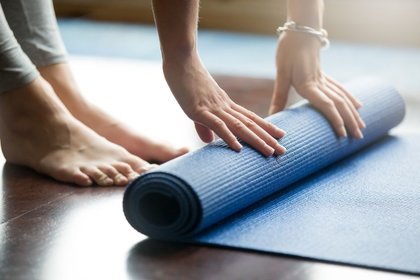 Person rolling up a yoga mat