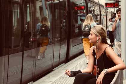 Woman with earphones in at a train station