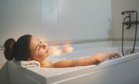 woman having a relaxing bath with candles