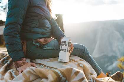 A woman overlooking the mountains with boxed water