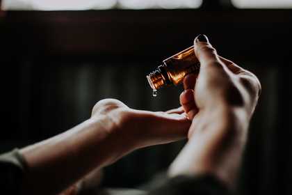 Hands pouring oil out of a bottle