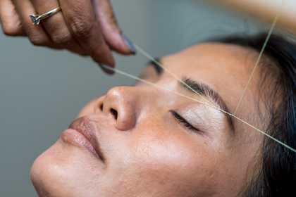 A woman having her eyebrows threaded