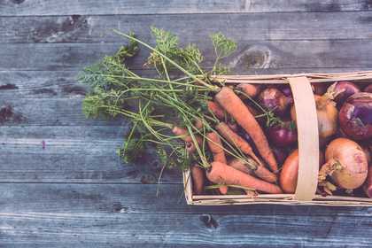 A wooden box with vegetables in