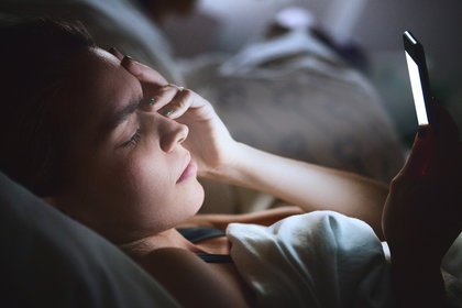 Woman on phone in bed