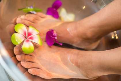 A person washing their feet with flowers