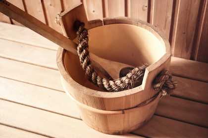 brown bucket with rope handle and spatula inside it