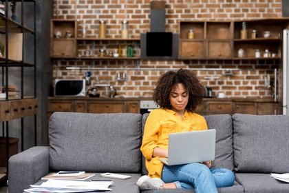Lady sat on the sofa on her laptop